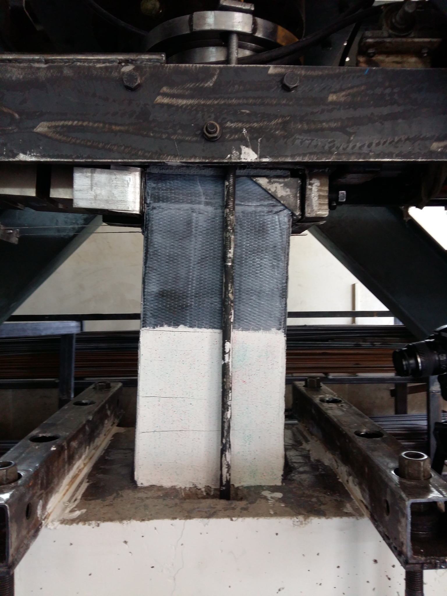 CFRP-strengthened concrete column in a structural loading frame
